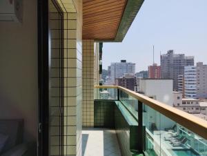 Elle comprend un balcon offrant une vue sur la ville. dans l'établissement Apartamento no canto do forte, à Praia Grande