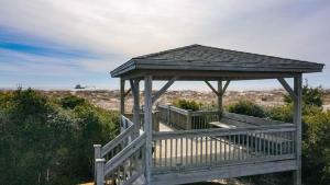 a wooden gazebo in the middle of a beach at Cypress Hall in Holden Beach