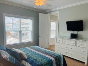 a bedroom with a bed and a flat screen tv at 287 OBW home in Holden Beach