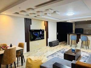 - un salon avec une télévision, une table et des chaises dans l'établissement Amazing Apartment Overlooking CityStars, au Caire