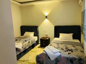 - une chambre avec 2 lits et une table de nuit dans l'établissement Amazing Apartment Overlooking CityStars, au Caire