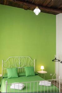 Dormitorio verde con cama y pared verde en Spaccanapoli Rooms Duomo, en Nápoles