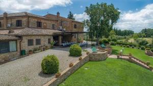 une grande maison en briques avec un jardin en face de celle-ci dans l'établissement Villa Boscarello 17, à Trequanda
