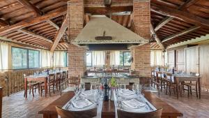 une grande salle à manger avec des tables et des chaises en bois dans l'établissement Villa Boscarello 17, à Trequanda