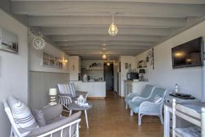 a living room with blue chairs and a kitchen at Biscarrosse Lac duplex 4 personnes classé 1 étoile in Biscarrosse