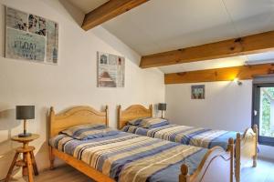 two beds in a bedroom with wooden floors at Biscarrosse Lac duplex 4 personnes classé 1 étoile in Biscarrosse