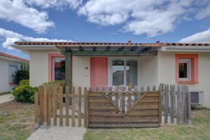 a house with a wooden gate in front of it at Biscarrosse T2 avec terrasse 4 couchages in Biscarrosse