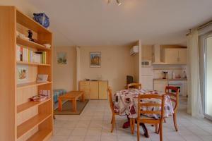 a kitchen and dining room with a table and chairs at Biscarrosse T2 avec terrasse 4 couchages in Biscarrosse +19 photos