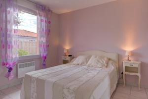 a white bedroom with a bed and a window at Biscarrosse T2 avec terrasse 4 couchages in Biscarrosse