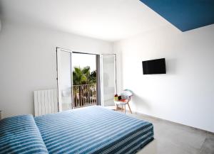 una camera con un letto blu e una finestra di sea&sun a Pozzallo