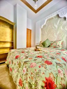 um quarto com uma cama grande e uma colcha floral em Casa Riad Amor Marrakech en Lo Pagan em San Pedro del Pinatar