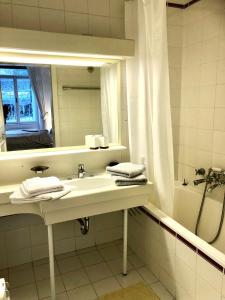 y baño con lavabo, espejo y bañera. en BRANDNEW - Executive Apartement 1 en Bad Gastein
