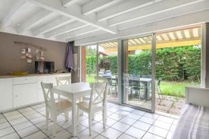 kuchnia i jadalnia ze stołem i krzesłami w obiekcie Biscarrosse Lac Duplex avec jardin 6 personnes w mieście Biscarrosse