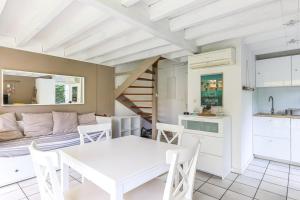 een keuken en een woonkamer met een witte tafel en stoelen bij Biscarrosse Lac Duplex avec jardin 6 personnes in Biscarrosse
