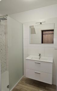 a white bathroom with a sink and a mirror at Chata Sára in Janske Lazne