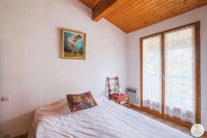 Schlafzimmer mit einem Bett und einem Fenster in der Unterkunft Biscarrosse Bourg, Maison pour 6 personnes avec Terrasse et jardin in Biscarrosse