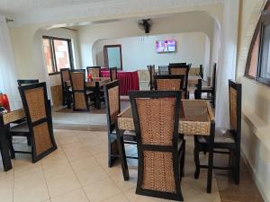 un comedor con mesas y sillas en un restaurante en Hotel Double N - Kisumu en Kisumu