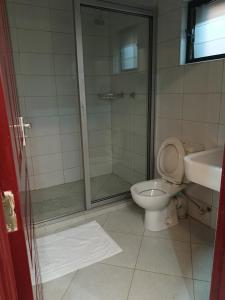 a bathroom with a shower and a toilet and a sink at Hotel Double N - Kisumu in Kisumu