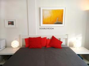 1 dormitorio con 1 cama con almohadas rojas en Loft 76, en Bremen