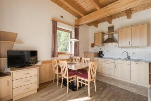 a kitchen with a table and chairs and a television at Residence Reisenschuh in Vipiteno