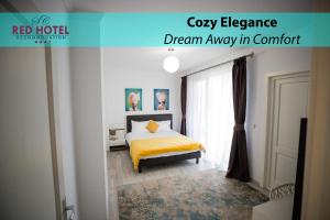 Red Hotel Riviera Suite&Lake في كلوي نابوكا: غرفة نوم بسرير وبطانية صفراء