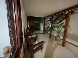 een woonkamer met een trap en een tafel en stoelen bij Asharam Asociación Argentina de Yoga in Mina Clavero