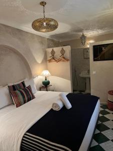 um quarto com uma cama grande e toalhas em Riad Alena em Marraquexe