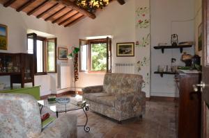 a living room with a couch and a chair at Agriturismo Villa Rosetta in San Severino Marche