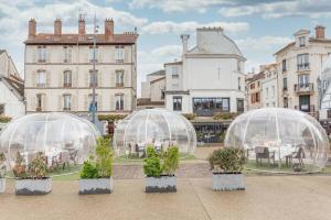 three glass domes with plants in them in a courtyard at Petite perle - Disneyland Paris in Lagny