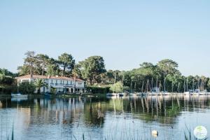 a house on a lake with boats in the water at Biscarrosse Bourg Appartement avec terrasse classé 1 étoile pour 4 personnes in Biscarrosse