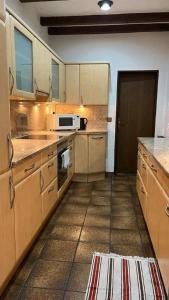 a kitchen with wooden cabinets and a microwave at Pension Highway Ferienwohnung Osnabrück in Osnabrück