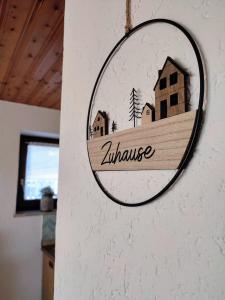 ein rundes Schild an der Wand mit einem Haus in der Unterkunft Ferienwohnung Lichtenauer Hof in Thyrnau