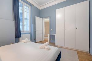 een slaapkamer met een groot bed en witte kasten bij MyKeypers Luxury Parisian Flat - Heart of Paris in Parijs