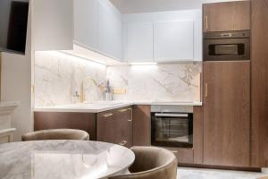 a kitchen with a table and chairs and a sink at MyKeypers Luxury Parisian Flat - Heart of Paris in Paris +18 photos