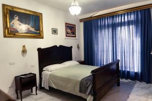 een slaapkamer met een bed en een schilderij aan de muur bij Romantico appartamento in Centro in Castiglione del Lago