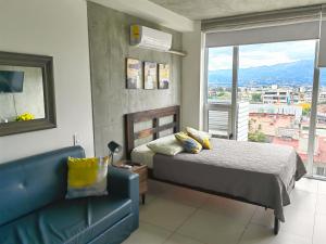 - une chambre avec un lit, un canapé et une fenêtre dans l'établissement 0509 iFreses Hermoso Apartamento con Aire Acondicionado y Parqueo, à Curridabat