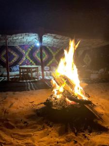 uma fogueira em frente a um edifício à noite em Mhamid Sahara Golden Dunes Camp - Chant Du Sable em Mhamid