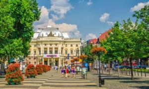 a large white building with people walking in front of it at Cozy, bright room with free parking in Bratislava