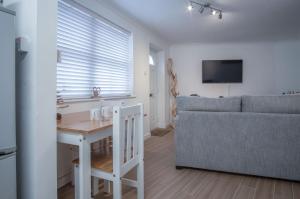 Castle Cove - 1 Bedroom Apartment - Tenby في تينبي: غرفة معيشة مع طاولة وأريكة