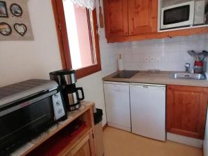 a small kitchen with a microwave and a sink at Appartement Saint-François-Longchamp, 2 pièces, 4 personnes - FR-1-635-105 in Saint-François-Longchamp
