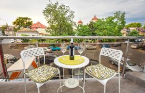 a balcony with a table and chairs and a view of a city at Bucharest Central Apartments - Shabbat Friendly in Bucharest