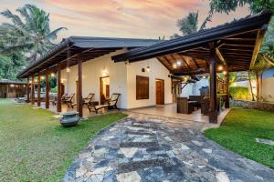 a house with a stone walkway in the yard at Villa Diyathra in Tangalle