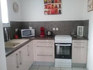 a kitchen with a stove and a microwave at Biscarrosse Bourg Charmant appartement T3 en centre ville in Biscarrosse