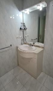 Baño blanco con lavabo y espejo en Apartamentos Nerja Bahia en Nerja