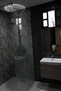 y baño con ducha acristalada y lavamanos. en VILLA MYAD en Marrakech