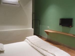 een slaapkamer met een bed en een tv aan de muur bij MY ROOMZ BANARAS in Varanasi +19 foto's