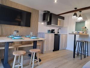 een keuken met een bar met krukken en een tv bij LA CASETA DELS HEROIS in Puigcerdà