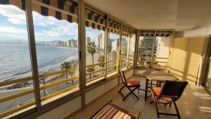 balkon ze stołem i krzesłami oraz widokiem na ocean w obiekcie Don Miguel 1-Fincas Benidorm w mieście Benidorm