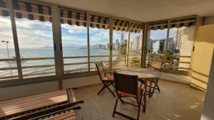 balkon ze stołem i krzesłami oraz widokiem na ocean w obiekcie Don Miguel 1-Fincas Benidorm w mieście Benidorm