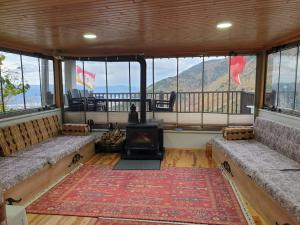 a living room with couches and a fireplace with a view at Uludağ ve Bursa manzaralı Lüks Dağ Evi in Yıldırım